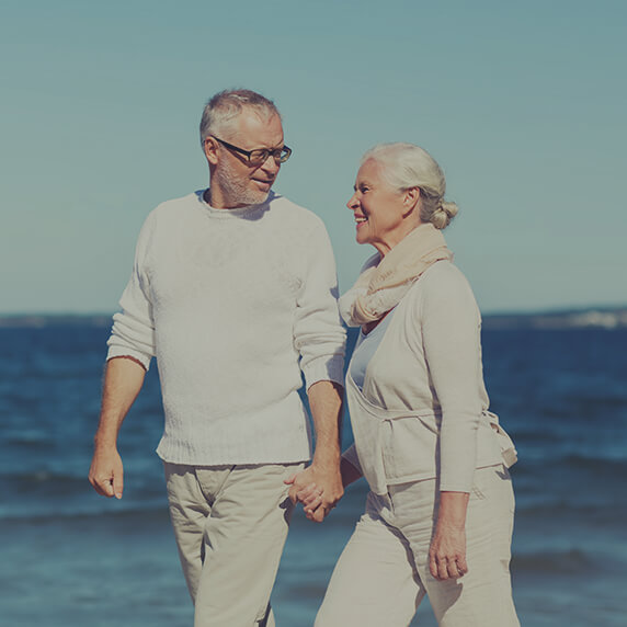 Older couple walking on beach